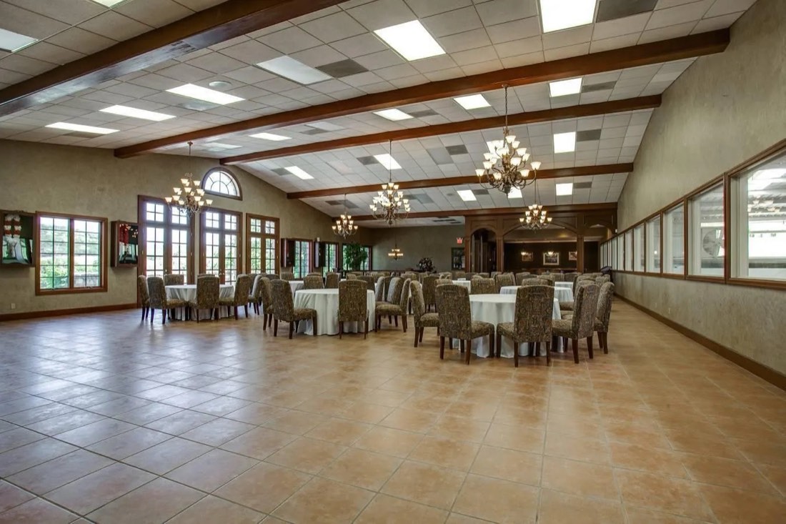 Second-floor banquet hall set with round tables and chandeliers