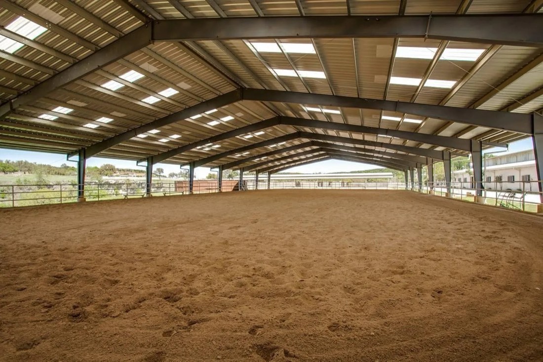 Covered open-air arena with steel frame and Hill Country views