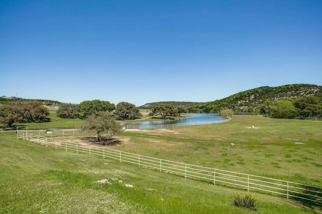 Lakes and fenced pasture beneath oak-covered hills